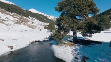 Arkasında nehir ve köy olan bir dağ manzarasının insansız hava aracı görüntüsü