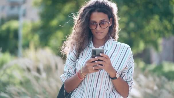 Vídeo Mulher Bonita Usando Seu Telefone Celular Enquanto Caminha Parque — Vídeo de Stock