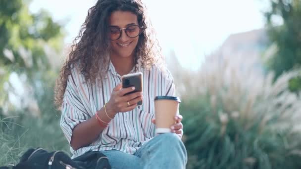 공원에서 커피를 마시면서 핸드폰을 사용하는 아름다운 여성의 — 비디오