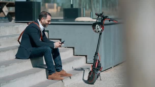 Wideo Eleganckiego Mężczyzny Korzystającego Telefonu Komórkowego Podczas Odpoczynku Jeździe Skuterze — Wideo stockowe
