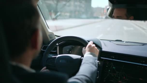 市内全域で車を運転するエレガントなビジネスマンのビデオ — ストック動画
