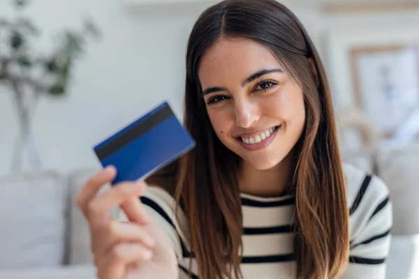 Potret Wanita Muda Tersenyum Memegang Kartu Kredit Sementara Duduk Sofa — Stok Foto