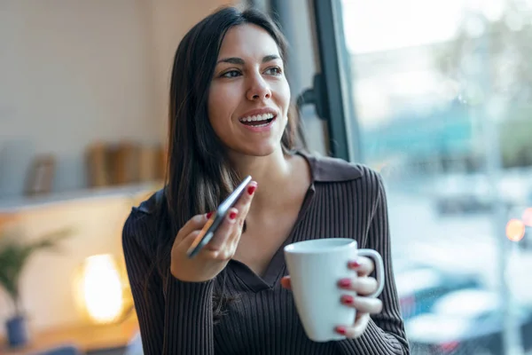 Snímek Krásné Mladé Ženy Pomocí Mobilního Telefonu Při Pití Kávy — Stock fotografie