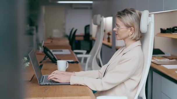 現代のオフィスでラップトップで働く成熟した建築家のエンジニアの女性のビデオ — ストック動画