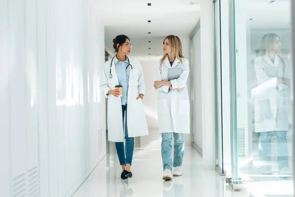 病院のデジタルタブレットで結果をコンサルティングしながら話している2人の魅力的な女性医師のショット — ストック写真