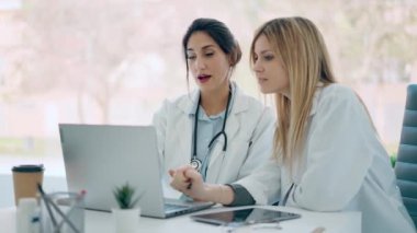 Tıbbi danışmanlık sırasında laptopuyla çalışan iki güzel kadın doktorun videosu.