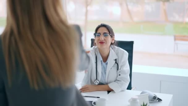 診察中に患者さんに医療を説明しながら話す美しい陽気な女性医師のビデオ — ストック動画