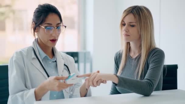 若い患者をケアしながら心臓や血圧を測定する美しい女性医師のビデオ — ストック動画