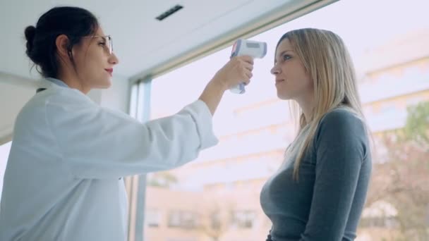 Neşeli Güzel Bir Kadın Doktorun Kadın Hasta Sıcaklığını Termometreyle Ölçtüğü — Stok video