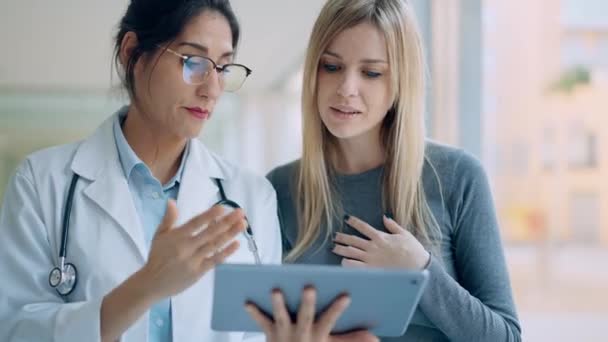 診察で患者にデジタルタブレットで医療を説明しながら話す美しい女性医師のビデオ — ストック動画