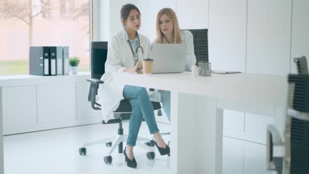 Vídeo Duas Belas Médicas Trabalhando Com Seu Laptop Enquanto Conversava — Vídeo de Stock