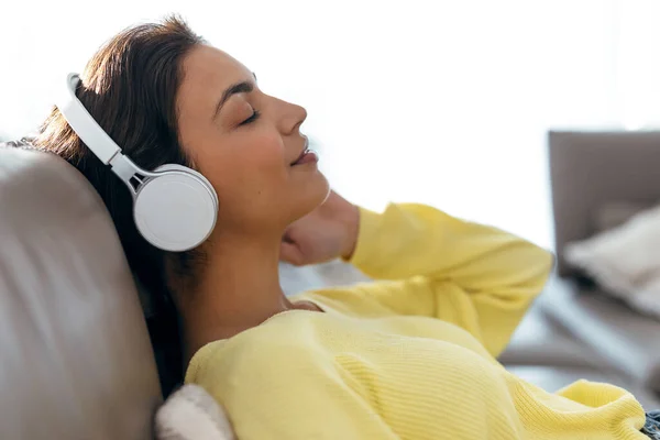 Evde Kanepede Uzanmış Akıllı Telefonuyla Müzik Dinleyen Rahat Bir Kadın — Stok fotoğraf
