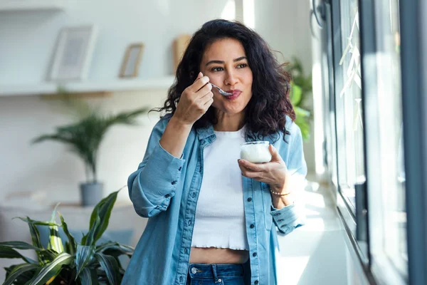 Shot Happy Beautiful Woman Eating Yogurt While Standing Living Room — Stock Photo, Image