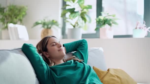 若いです疲れている女性のビデオをリラックスソファとともに枕のために胃のためにリビングルームに自宅 — ストック動画