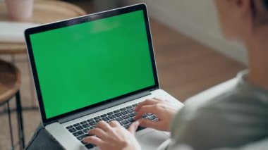 Evdeki kanepede otururken dizüstü bilgisayarıyla çalışan güzel bir genç kadının videosu..