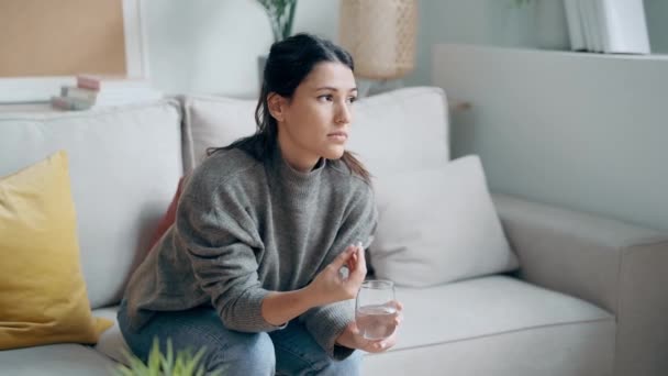 伤心的女人坐在沙发上吃药的录像 — 图库视频影像