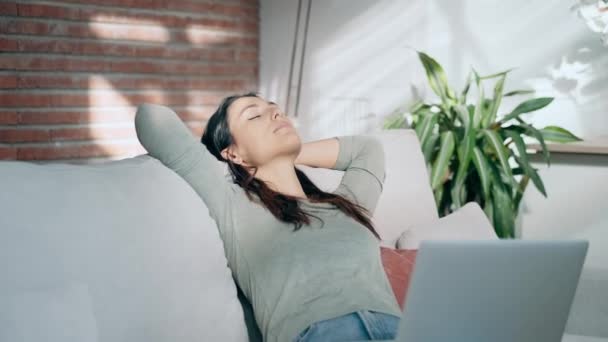 若い疲れた女性のビデオ リビングルームのソファーに横たわるラップトップと仕事の休憩を取っている間リラックス — ストック動画