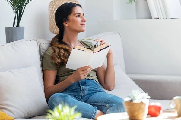 Tiro Mulher Confiante Lendo Livro Enquanto Sentado Sofá Casa — Fotografia de Stock