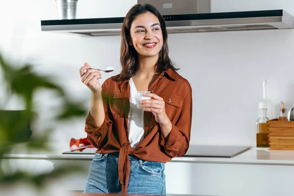 Egy Gyönyörű Boldog Joghurtot Eszik Miközben Előre Néz Otthon Konyhában — Stock Fotó