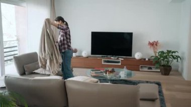 Evdeki oturma odasını temizleyen ve düzenleyen güzel bir kadının hızlı kamerası var.