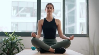 Evde yoga yapan sportif bir kadının videosu.