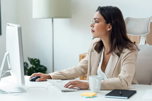 オフィスでコンピュータを使用するエレガントなスマートビジネス女性のショット — ストック写真