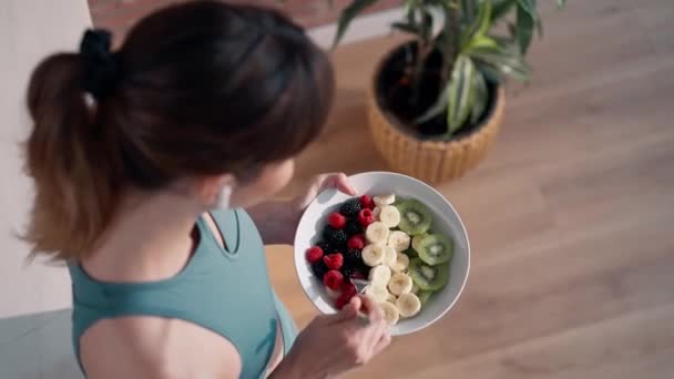Video Bella Donna Sportiva Mangiare Una Ciotola Sana Frutta Mentre — Video Stock