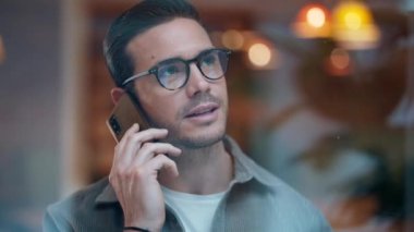 İş yerinde akıllı telefonla konuşan yakışıklı bir girişimcinin videosu.