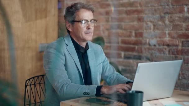 Βίντεο Του Ώριμου Χαλαρωτικού Επιχειρηματία Ραβδώσεις Ενώ Εργάζονται Φορητό Υπολογιστή — Αρχείο Βίντεο
