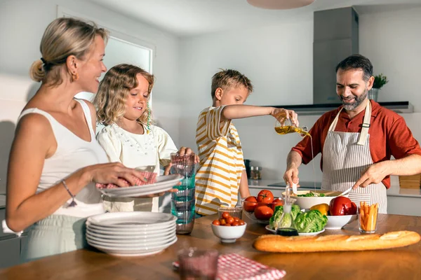 Shot of beautiful kind family cooking healthy salad together in the kitchen at home