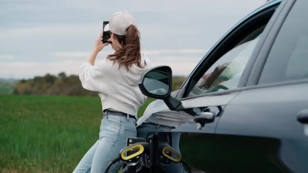 一个美丽的年轻女子用智能手机拍照的视频 当她停下车去看大自然的时候 — 图库视频影像