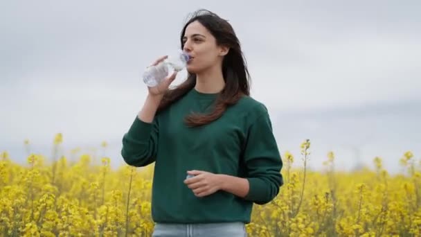 Video Beautiful Young Woman Drinking Water While Enjoying Spring Field — Stock Video