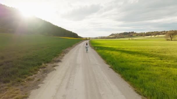 レイプされたフィールドで自転車に乗る美しい若い女性のドローンビューのビデオ — ストック動画