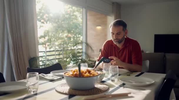 Video Pohledný Koncentrovaný Muž Pomocí Smartphone Při Posezení Před Obědem — Stock video