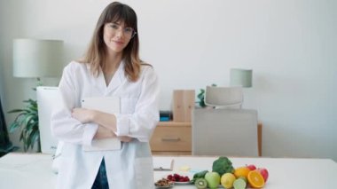 Beslenme danışmanlığında kameraya bakarken dijital tabletle çalışan güzel ve zeki bir beslenme uzmanı kadının videosu.