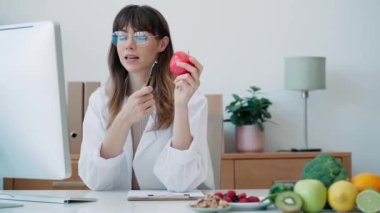 Beslenme danışmanlığında video görüşmesi yaparken bilgisayarla çalışan güzel ve zeki bir beslenme uzmanı kadının videosu.