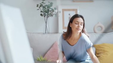 Evdeki oturma odasında test ederken elinde gerekli yağı tutan neşeli bir kadının videosu.