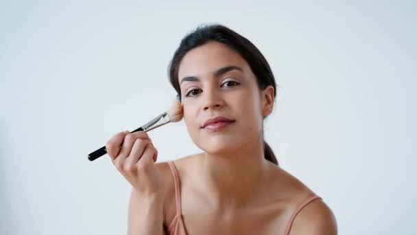 Video Hermosa Mujer Joven Haciendo Maquillaje Mientras Mira Cámara Blanco — Vídeo de stock