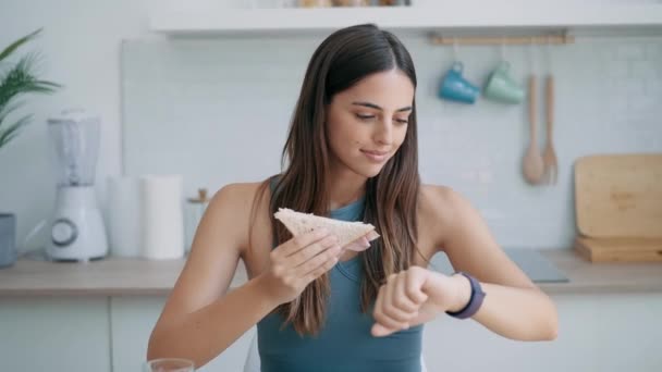 Βίντεο Της Όμορφης Αθλητική Γυναίκα Τρώει Υγιή Sanwich Ενώ Κοιτάζοντας — Αρχείο Βίντεο