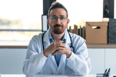 Danışmanlıkta kameraya bakarken bilgisayarla video görüşmesinde olgun bir erkek doktorun görüntüsü..