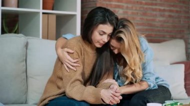 Evdeki kanepede otururken üzgün arkadaşını destekleyen ve rahatlatan güzel bir genç kadının videosu..