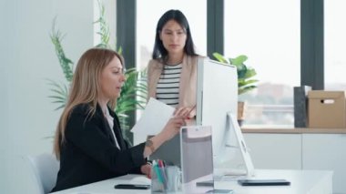 İki iş kadınının birlikte çalıştığı bir iş yerinde notlara danışmanlık yaparken dizüstü bilgisayarla birlikte çalıştığı video.