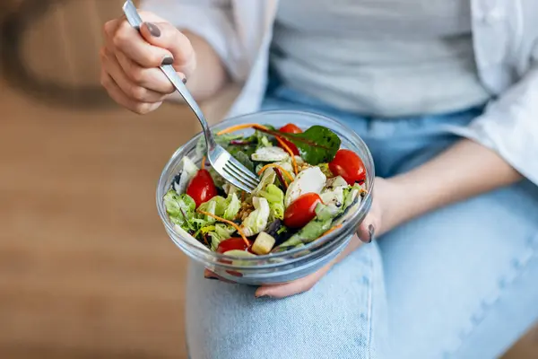 Jovem Mulher Comendo Salada Saudável Enquanto Sentado Cozinha — Fotografia de Stock