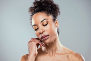 Kendini izole edilmiş kahverengi arka planda seyreden güzel bir genç kadın fotoğrafı.