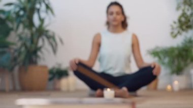 Video of sporty young woman doing yoga and hypopressive exercises while staying in lotus position in living room at home.