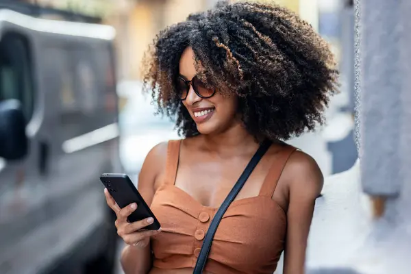 Şehirde Alışveriş Torbaları Taşırken Akıllı Telefon Kullanan Gülümseyen Kadına Yaklaş — Stok fotoğraf