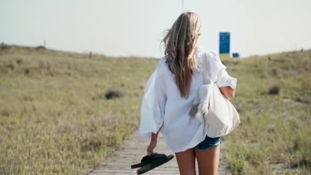 Video Hermosa Mujer Joven Caminando Playa Mientras Mira Cámara — Vídeos de Stock