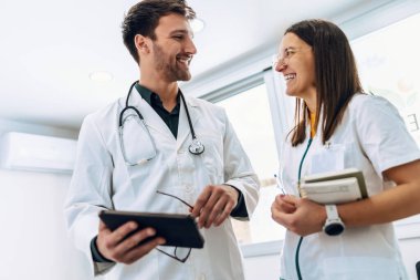 Tıbbi konsültasyonda tıbbi bilgiler hakkında konuşan akıllı kadın ve erkek doktorların iğnesi.