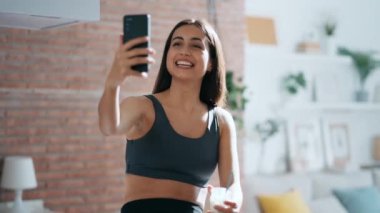 Etkilenen sportif kadın videosu. Evdeki mutfakta iogurt yerken blog için video hazırlıyor.