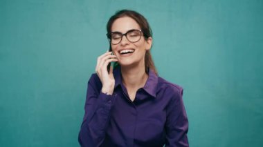 Güzel bir kadının akıllı telefonuyla kameranın önünde poz verdiği görüntüler.
